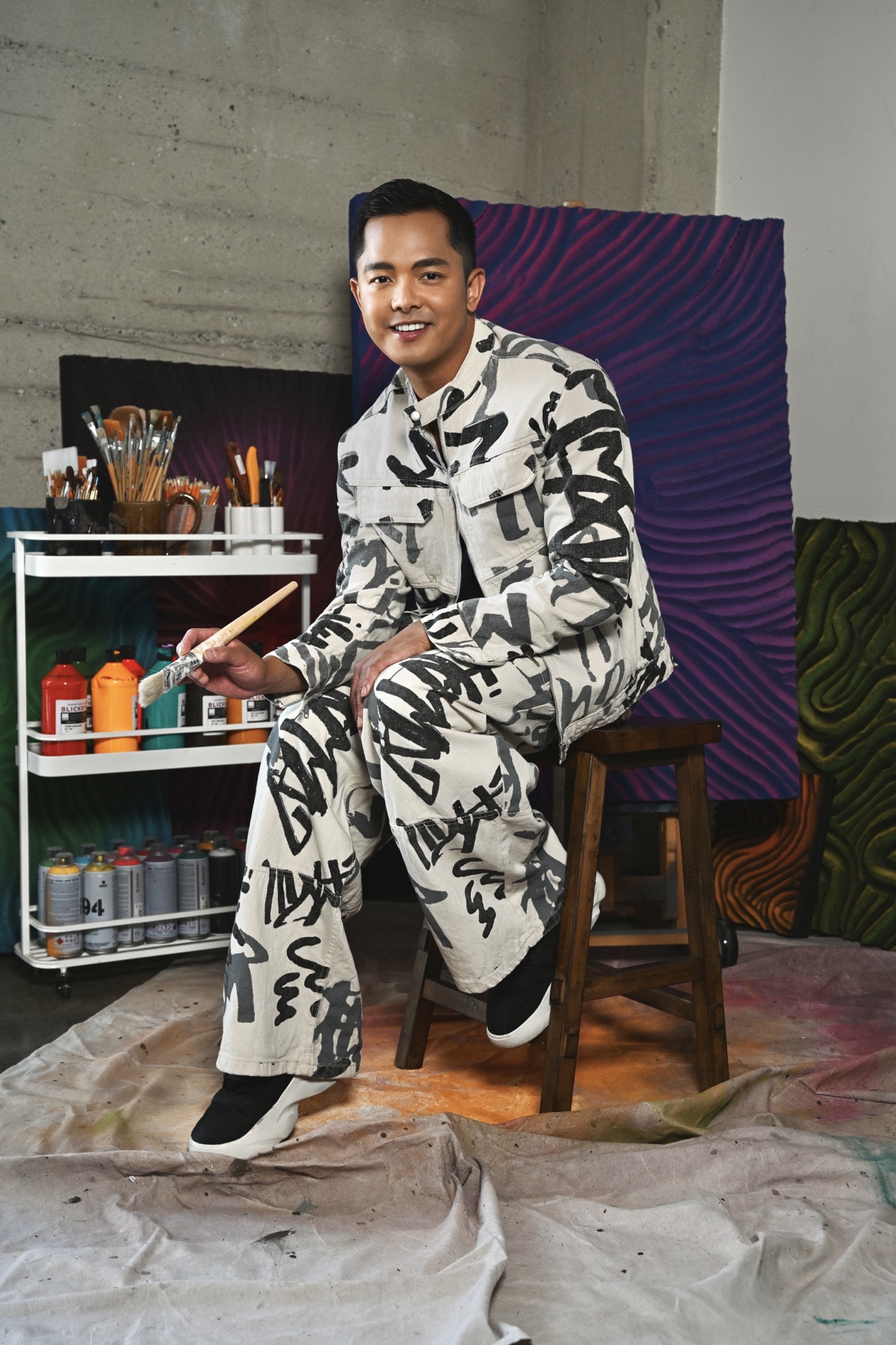 Patrick in a black-and-white brushstroke print jumpsuit against a plain backdrop